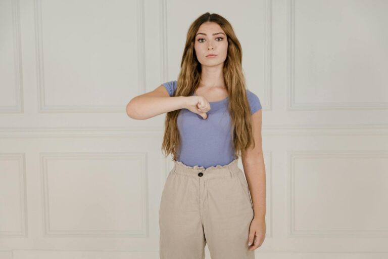 Young woman gesturing in sign language indoors, expressing communication visually.